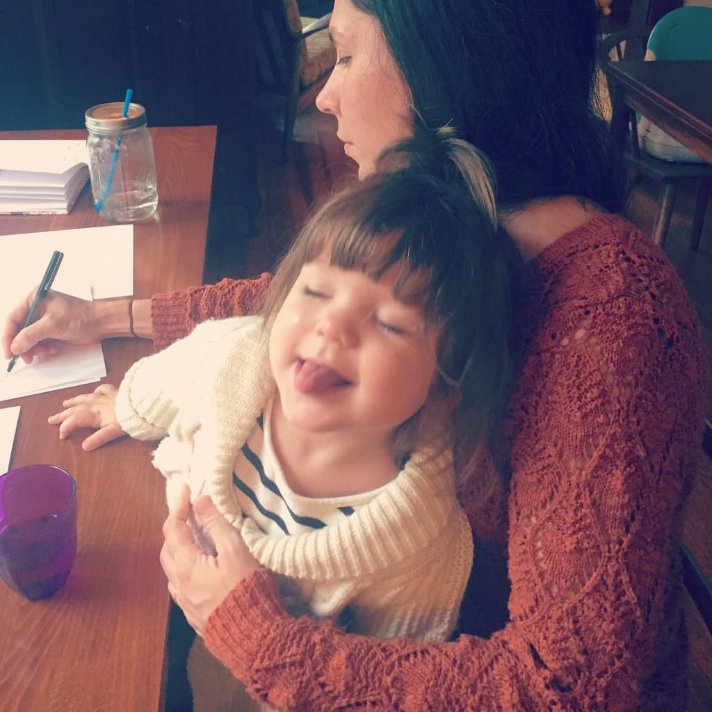 Photo of Marsha holding her young daughter while writing